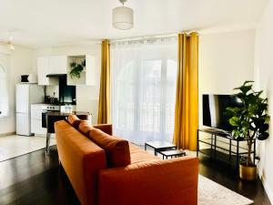 a living room with a couch and a kitchen at Appartement cosy près de Disneyland Paris in Serris