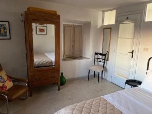 a bedroom with a dresser and a bed and a chair at Casa Oliva Casperia, house & private olive grove in Casperia