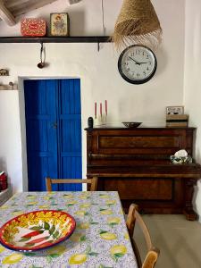 a dining room with a table and a clock on the wall at Casa Oliva Casperia, house & private olive grove in Casperia
