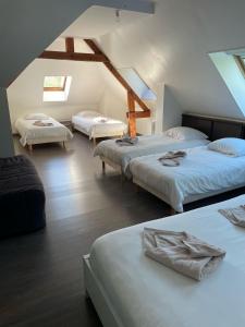 a bedroom with three beds in a attic at Grande villa avec piscine chauffée et Jacuzzi in Mouen