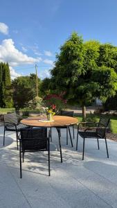 Una mesa de madera con sillas y una mesa con flores encima. en Helles Ferienhaus mit 2 Terrassen, en Uttenweiler 14 fotos más