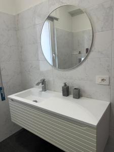 une salle de bain avec un lavabo blanc et un miroir dans l'établissement Room 17, à Diamante