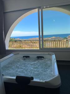 a bath tub with two dogs in it next to a window at Room 17 in Diamante +2 photos