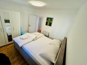 a bedroom with a bed with white sheets and pillows at Apartment Novigrad Holiday in Novigrad Dalmatia