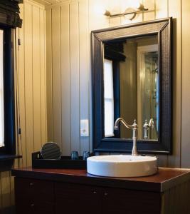 a bathroom with a sink and a large mirror at Au coeur de la Vallée in Érezée