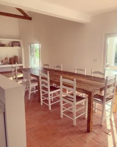 a dining room with a wooden table and chairs at Monte do Poço Country House in Erra