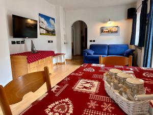 a living room with a table and a blue couch at Cesa Bernard - Apartment Cima 12 e new Apartment Fraine in Pozza di Fassa
