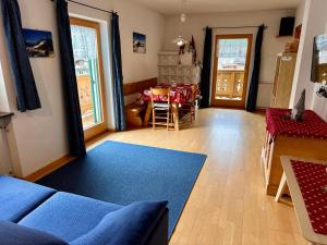 a living room with a blue couch and a table at Cesa Bernard - Apartment Cima 12 e new Apartment Fraine in Pozza di Fassa