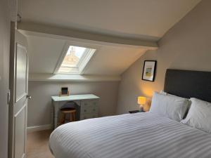 a bedroom with a white bed and a window at Brantwood Cottage in Keldhead +6 photos