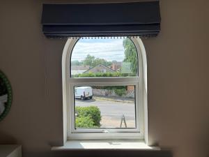 an arched window with a van parked in a parking lot at Brantwood Cottage in Keldhead