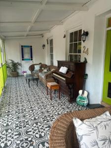 a living room with a piano and a couch at Greyton Toad Hall in Greyton