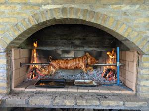 a cow is cooking in a brick oven at Vila Restart Čortanovci in Čortanovci