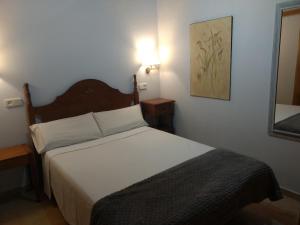 a bedroom with a large bed with a wooden headboard at Apartamento con jardin en Gessa in Gessa