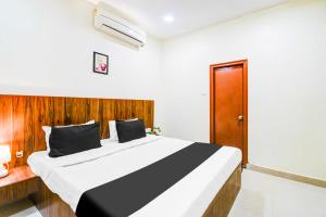 a bedroom with a large bed with a wooden headboard at Townhouse Oak Begumpet Railway Station in Hyderabad