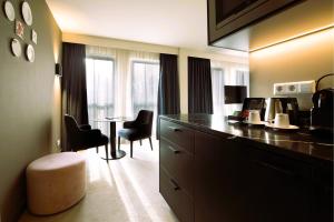 a hotel room with a desk and a table with chairs at Pestana Amsterdam Riverside in Amsterdam