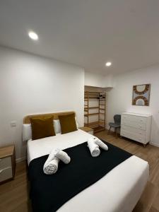a bedroom with a large bed with towels on it at VTZ Los Balcones del Casco in Zaragoza