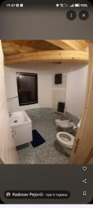 a bathroom with a toilet and a sink and a tv at Castelo 2025 in Vrnjačka Banja