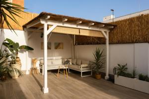 a white pergola with a couch on a patio at La Brisca Sun & Soul Pedregalejo in Málaga