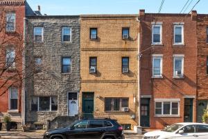 an apartment building with a black car parked in front of it at Design-led 1br In Prime Spot in Philadelphia
