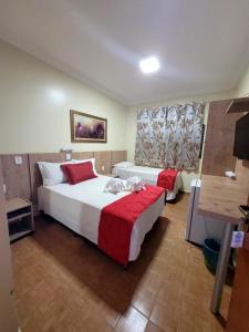カルダス・ノバスにあるHotel CANTO DA SERRAのベッド2台とテレビがあるホテルの部屋