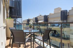 a balcony with a table and chairs on top of a building at Casa Fina in Estepona +23 photos
