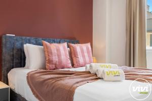 a bed with pink and white pillows on it at Casa Fina in Estepona