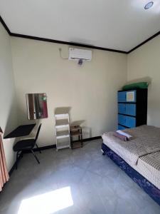 a bedroom with a bed and a desk and a chair at Parkside nest-studio 3 in Kuta Lombok