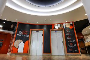 two doors in a building with a sign on the wall at The Originals Boutique, Hôtel Le Marmotel, Clermont-Ferrand in Clermont-Ferrand