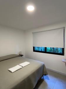 ein weißes Zimmer mit einem Bett mit einem Fenster in der Unterkunft Casa a estrenar en bosque de El Ensueño, Santa Ana in Santa Ana