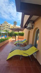 een patio met stoelen en een parasol op een gebouw bij Casa Amarela - Albufeira in Albufeira