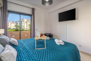 a bedroom with a bed with a table on it at Spacious & Sunny Apartment with Pool by HostWise in Portimão