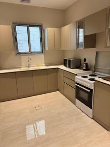 a kitchen with white cabinets and a stove at Luxury Apartment with 3 bed room in Al Khobar