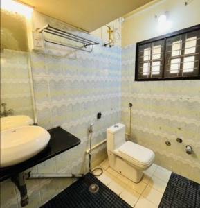 une salle de bain avec des toilettes blanches et un lavabo dans l'établissement Anagha Homestay Chikmagalur, à Chikmagalur
