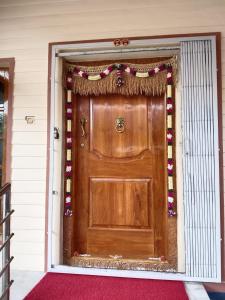 une maison avec une porte en bois avec une guirlande dans l'établissement Anagha Homestay Chikmagalur, à Chikmagalur