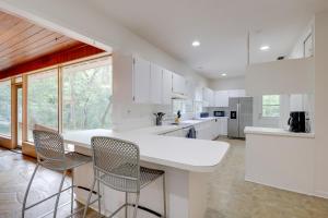 a kitchen with white cabinets and a counter with chairs at Vacation Home Rental in Gainesville, Florida! in Gainesville