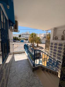 a balcony with a blue railing and a view of a courtyard at Duplex lumineux à Sidi bou said in Dar Salah Bey