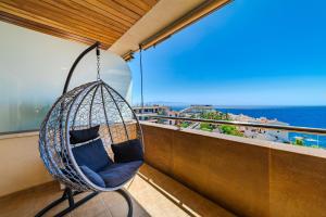 a swing on a balcony with a view of the ocean at Hermitage Homes BLG in Puerto de Santiago