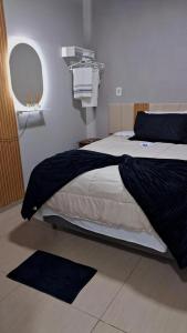 a bedroom with a bed with a black blanket at Refúgio Vida & Brisa in Pelotas