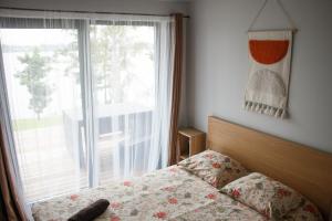 a bedroom with a bed and a large window at Krastos - māja Sams in Maurēni
