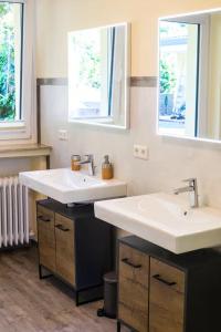 a bathroom with two sinks and two windows at Whirlpool, Billiard, Sauna! Ferienhaus Lacher in Baiersbronn +30 photos