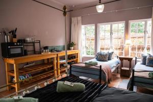 Una sala de estar con dos camas y un televisor. en Greyton Toad Hall Guesthouse - individual rooms, en Greyton