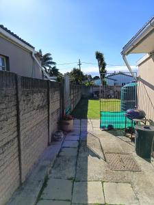 una cerca en un patio al lado de una casa en San-Lou Airbnb, en Sunridge Park