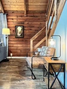 a living room with wooden walls and a couch and a table at Large Cabin w Hot Tub, Pond, Deck, Fire Pit, WiFi in Morton Grove