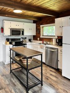 a kitchen with white cabinets and a table in it at Large Cabin w Hot Tub, Pond, Deck, Fire Pit, WiFi in Morton Grove