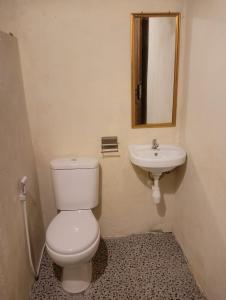 um banheiro com vaso sanitário e pia em Lalinggo bungalo em Tetebatu