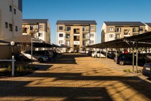 a parking lot with cars parked in front of buildings at #AlimamaSpaces Manson's Fynbos Villa in Cape Town