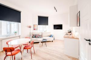 Una sala de estar con una mesa y sillas y un sofá. en Apartamenty Stary Rynek, Old Town self-check in, en Poznan