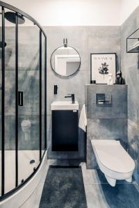 Un baño con ducha, inodoro y lavabo. en Apartamenty Stary Rynek, Old Town self-check in, en Poznan
