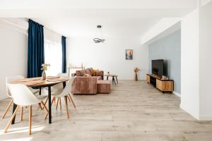 a living room with a table and a couch at Premium Tulip Apartments in Tunari