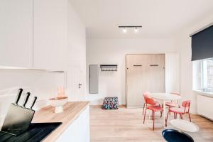 Una cocina blanca con una mesa y sillas rojas. en Apartamenty Stary Rynek, Old Town self-check in, en Poznan 8 fotos más